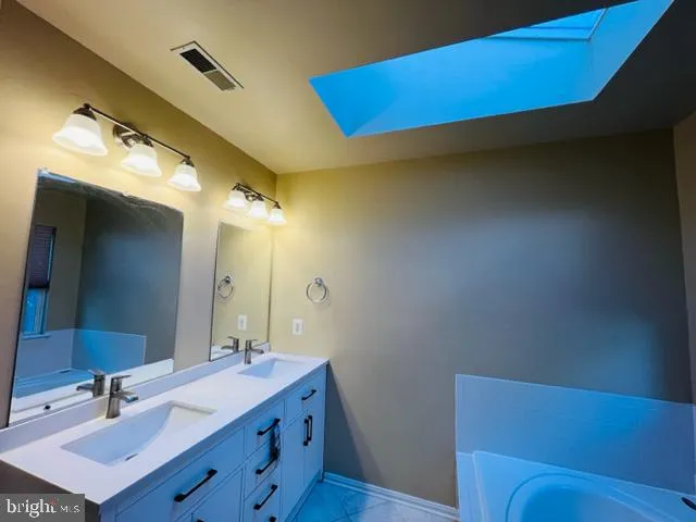 a bathroom with a sink vanity and a mirror