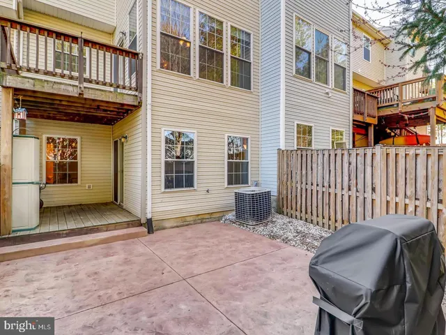 a view of backyard with wooden fence and large trees