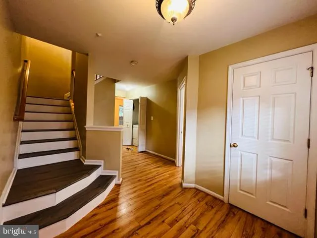 a view of a hallway with wooden floor and staircase