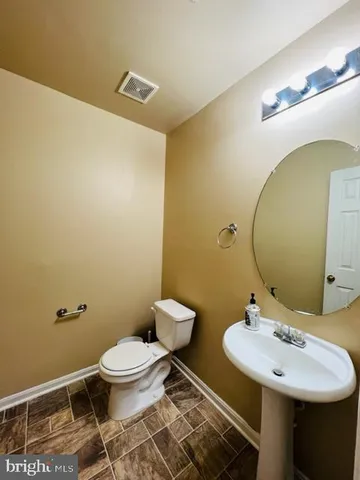 a bathroom with a sink mirror vanity and toilet