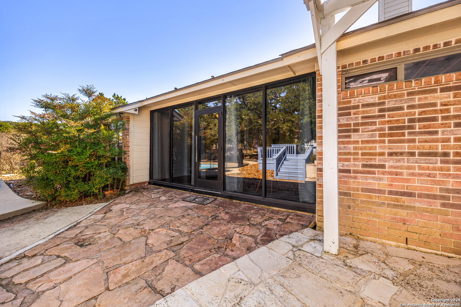 166 Bridle Path Spring Branch, TX 78070 - Photo 28 of 48 a view of a porch with a floor to ceiling window next to a yard