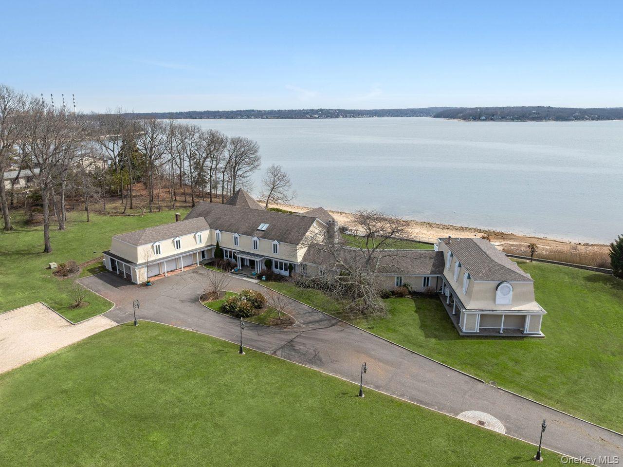 33 Beach Road Northport, NY 11768 - Photo 4 of 50 a picture of a lake with lawn chairs and a big yard