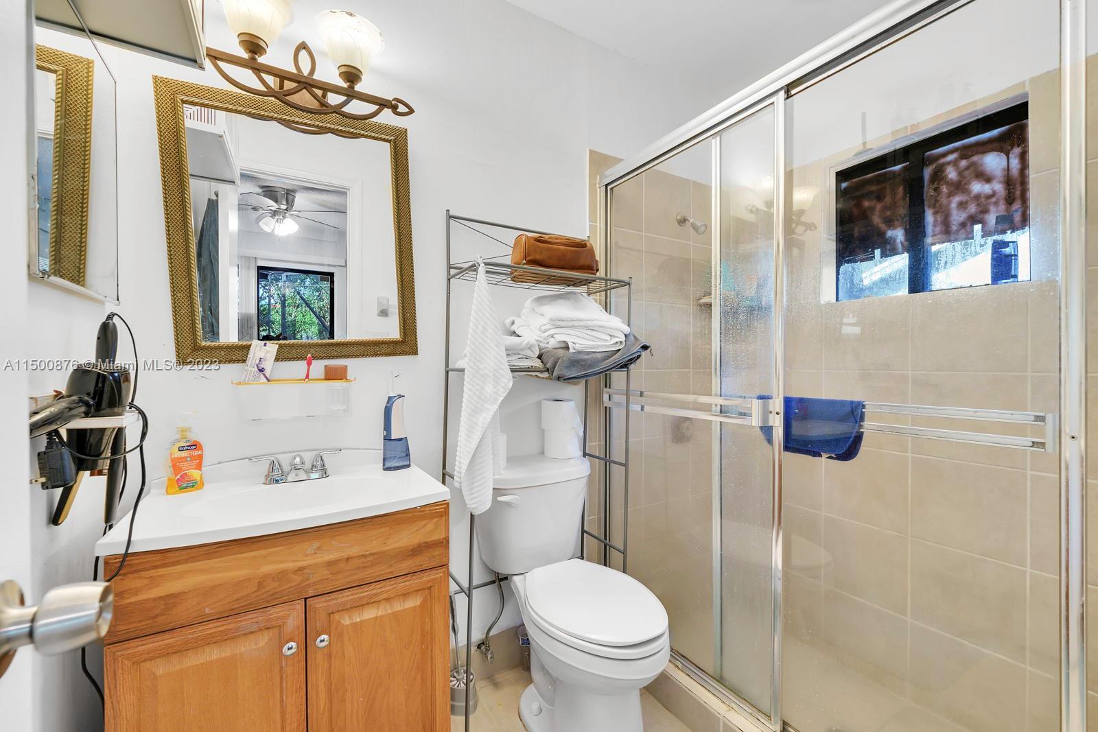9883 Liberty Court Boca Raton, FL 33434 - Photo 12 of 29 a bathroom with a toilet sink and mirror