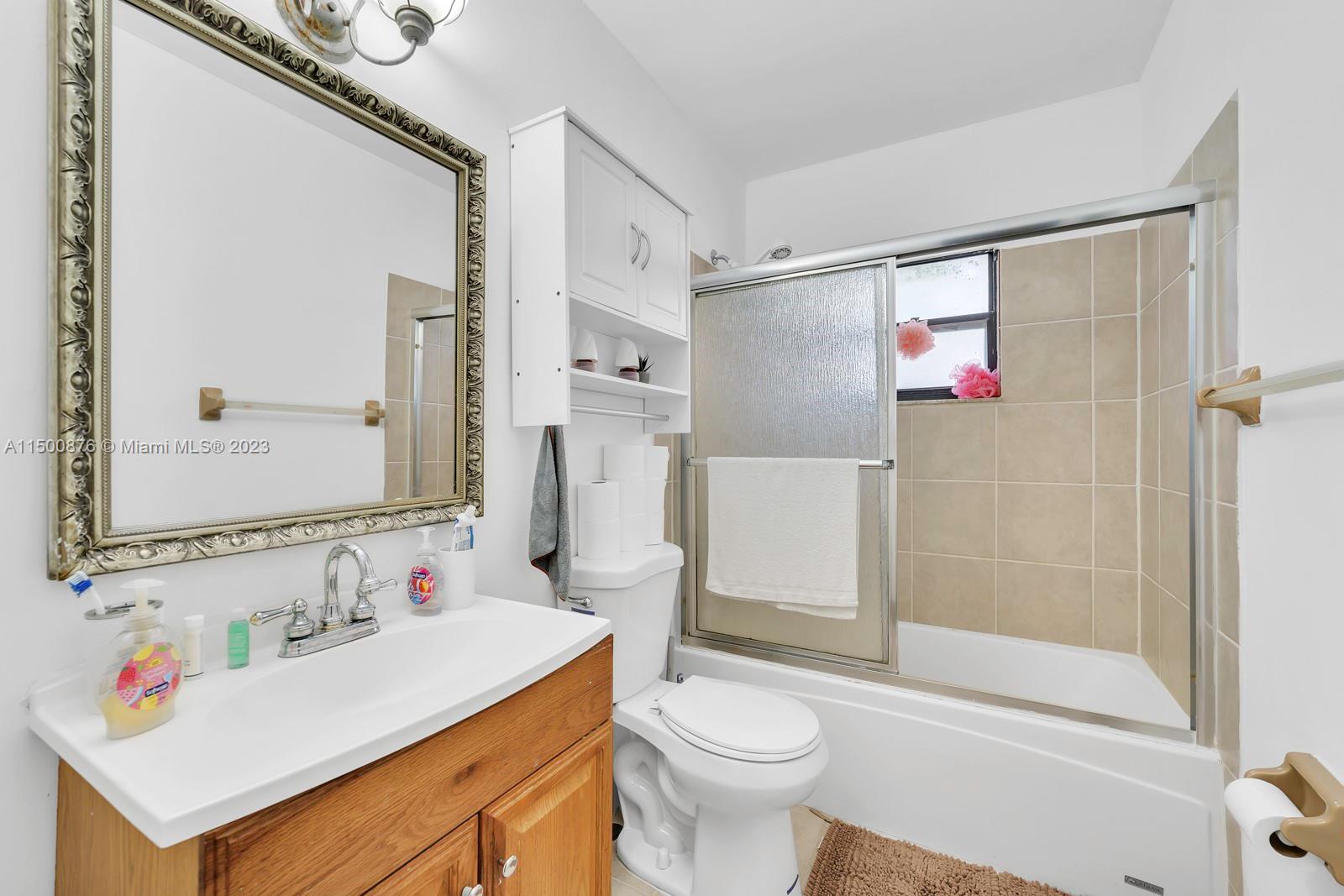 9883 Liberty Court Boca Raton, FL 33434 - Photo 9 of 29 a bathroom with a sink vanity mirror bathtub shower and a toilet
