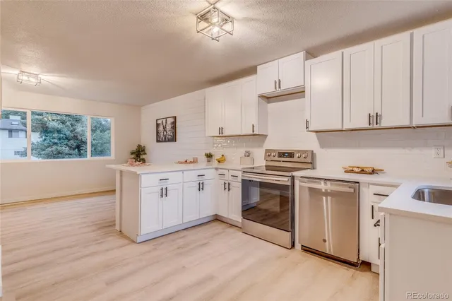 a kitchen with granite countertop white cabinets and white appliances