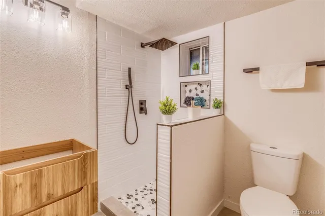 a bathroom with a granite countertop shower and a toilet