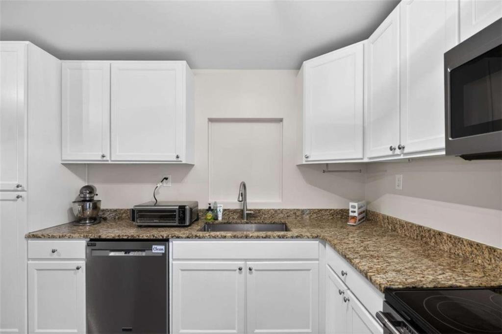 507 Grogan Road Buchanan, GA 30113 - Photo 13 of 31 a kitchen with stainless steel appliances granite countertop white cabinets sink and dishwasher