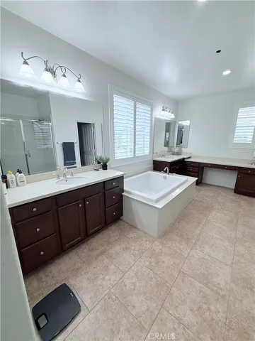 a spacious bathroom with a tub double sink window and mirror