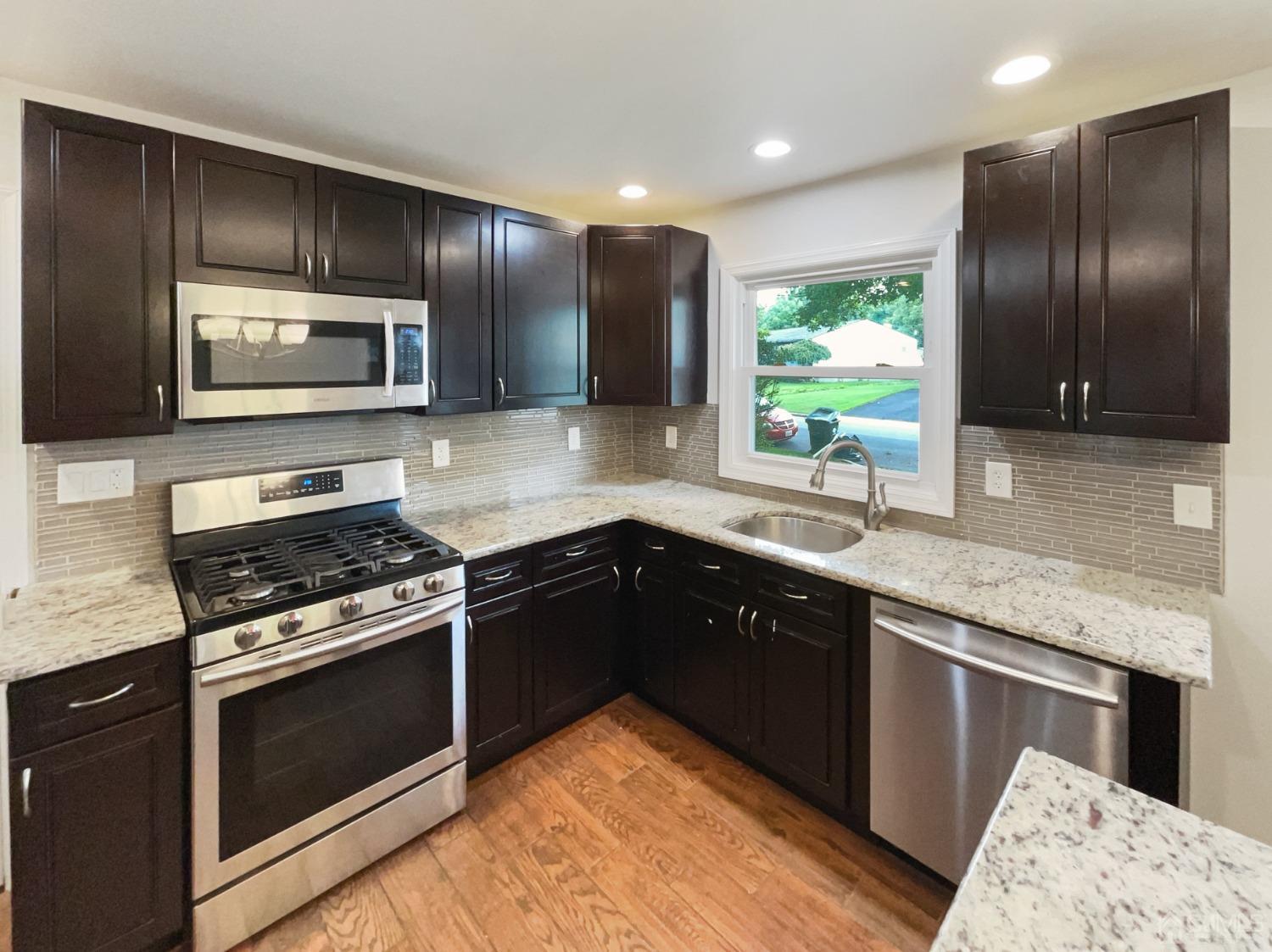 19 Clemson Road Old Bridge, NJ 08859 - Photo 11 of 23 a kitchen with stainless steel appliances granite countertop wooden cabinets and a stove top oven