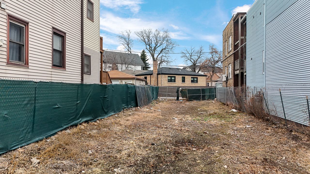 3675 North Elston Avenue Chicago, IL 60618 - Photo 5 of 19 a view of a house with a small yard and wooden fence