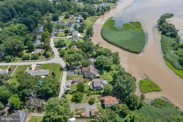 an aerial view of a house with a yard and greenery space
