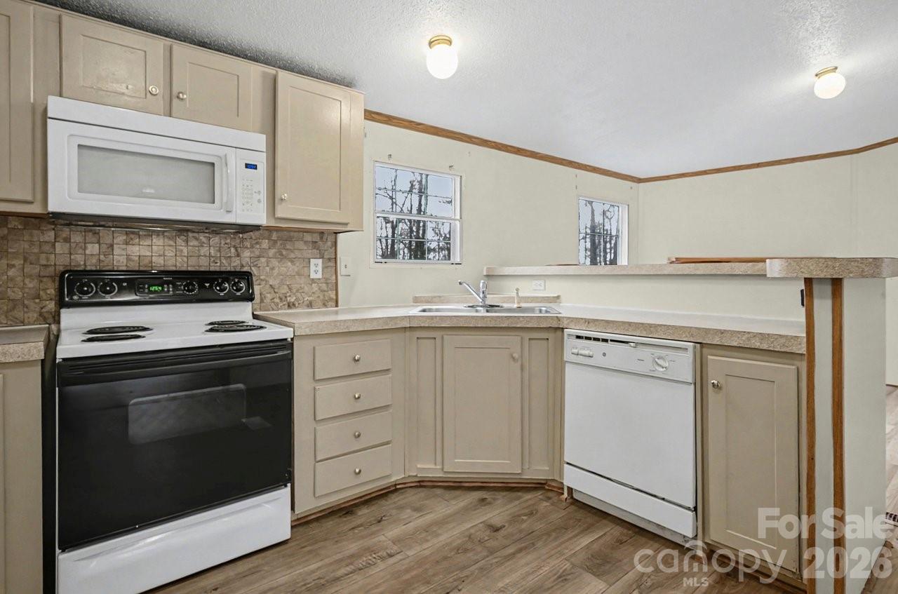 40348 Barnhardt Road New London, NC 28127 - Photo 13 of 38 a kitchen with white cabinets stainless steel appliances and sink