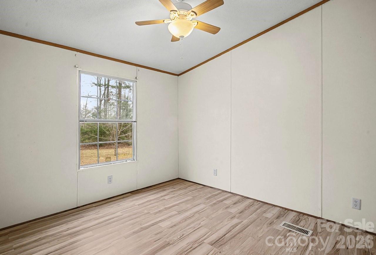 40348 Barnhardt Road New London, NC 28127 - Photo 29 of 38 an empty room with a window and a ceiling fan