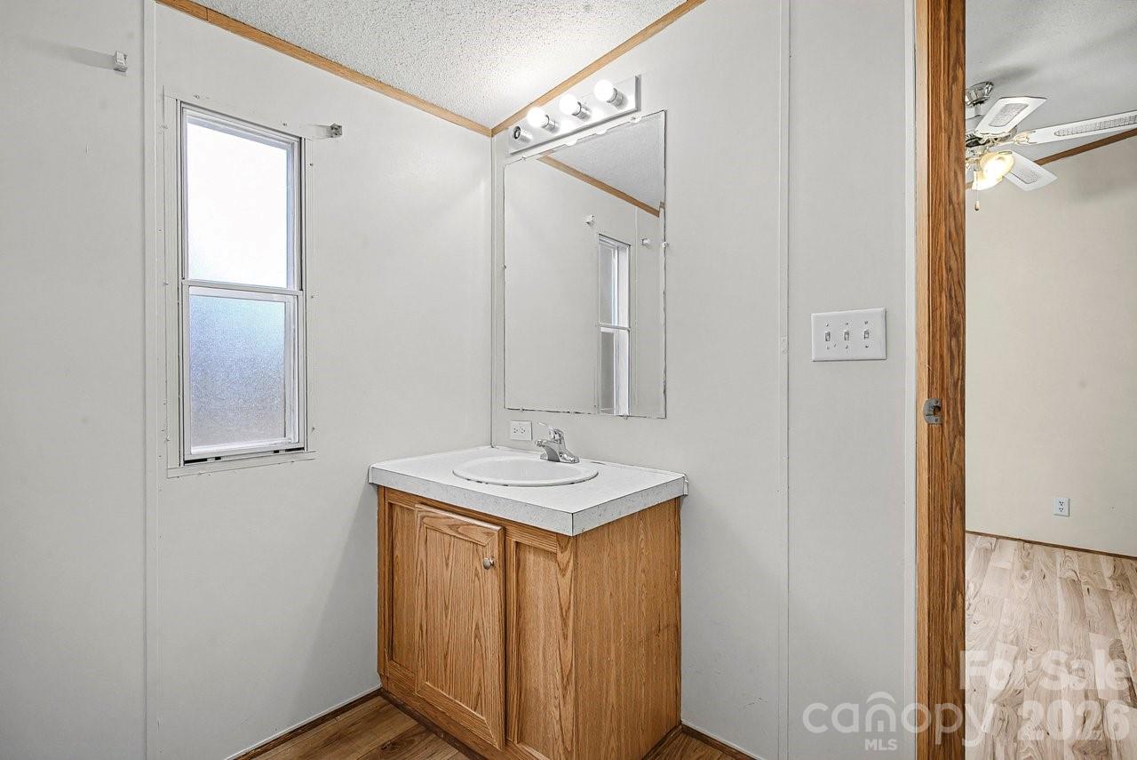 40348 Barnhardt Road New London, NC 28127 - Photo 31 of 38 a bathroom with a sink a mirror and a shower