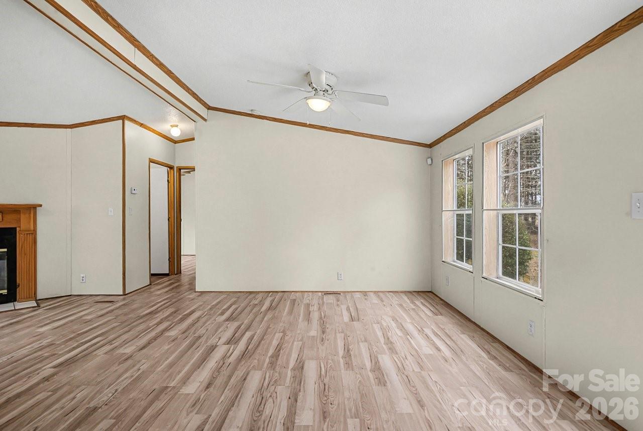 40348 Barnhardt Road New London, NC 28127 - Photo 6 of 38 a view of empty room with wooden floor and fan