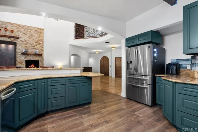 a large kitchen with stainless steel appliances granite countertop a refrigerator and a sink