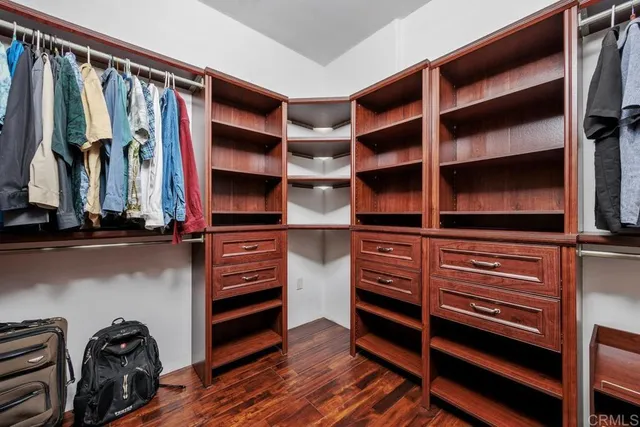 a view of walk in closet with clothes and shoes