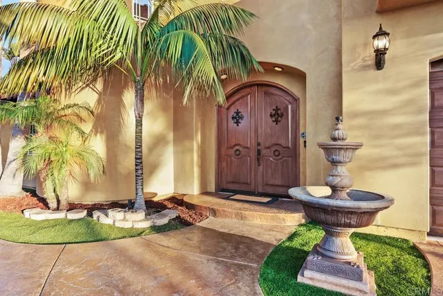 a view of a house with a small yard plants and a fountain