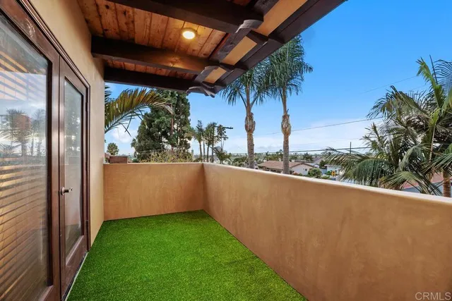 a view of a balcony with a yard