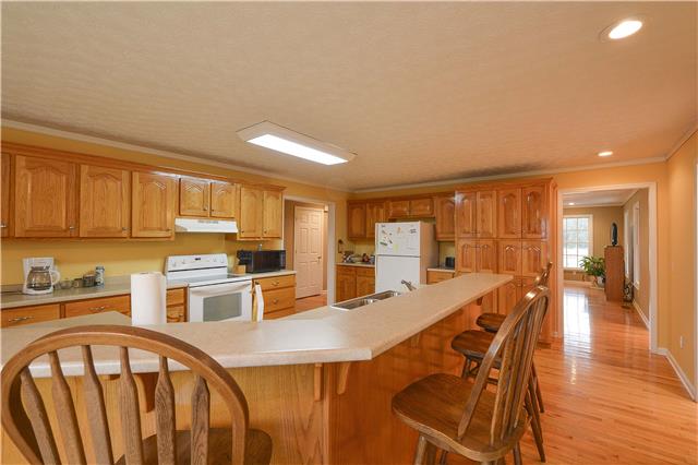 272 Revilo Road Leoma, TN 38468 - Photo 9 of 20 a kitchen with stainless steel appliances granite countertop a stove a sink dishwasher and cabinets with wooden floor