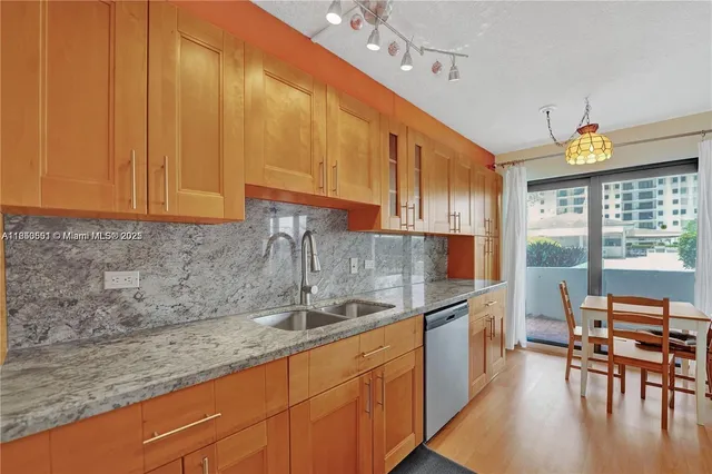 a kitchen with stainless steel appliances granite countertop a sink a stove and a refrigerator