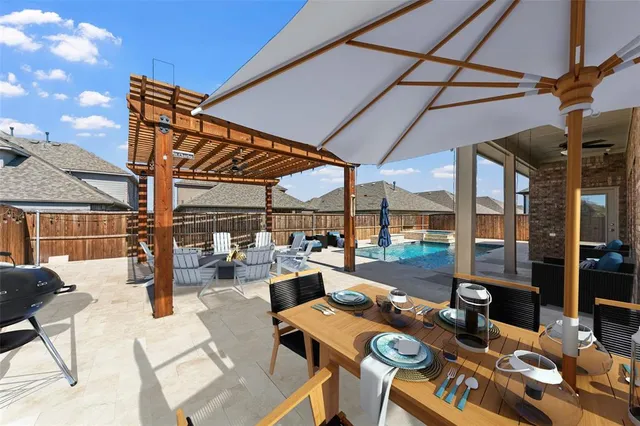 a roof deck with table and chairs and potted plants