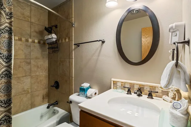 a bathroom with a sink vanity mirror and toilet