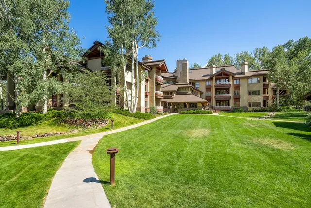 swimming pool with table and chairs under an umbrella