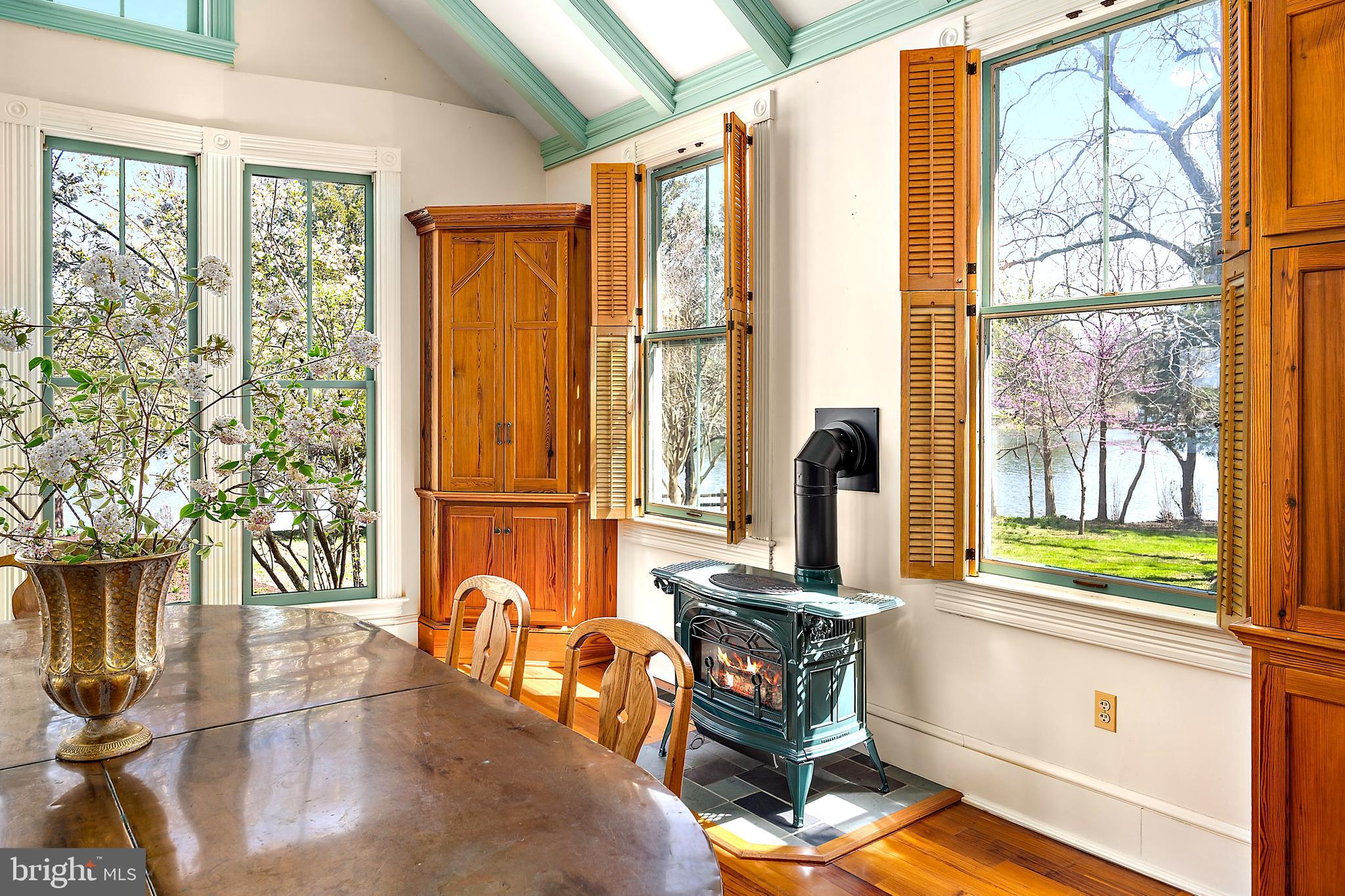 26090 Royal Oak Road Easton, MD 21601 - Photo 19 of 74 a view of a dining room with furniture a chandelier and large windows