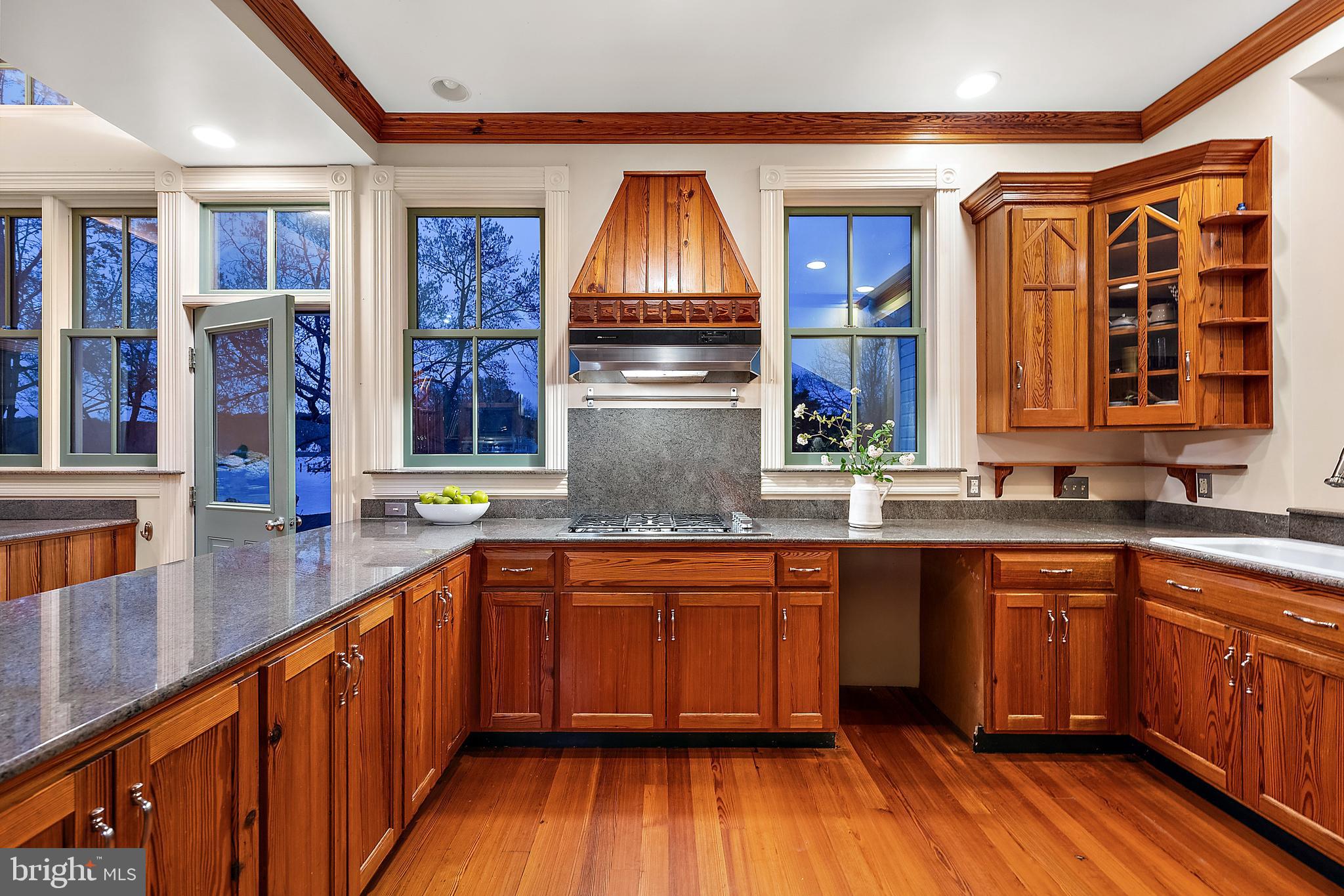 26090 Royal Oak Road Easton, MD 21601 - Photo 23 of 74 a kitchen with stainless steel appliances wooden floors wooden cabinets a sink and a window