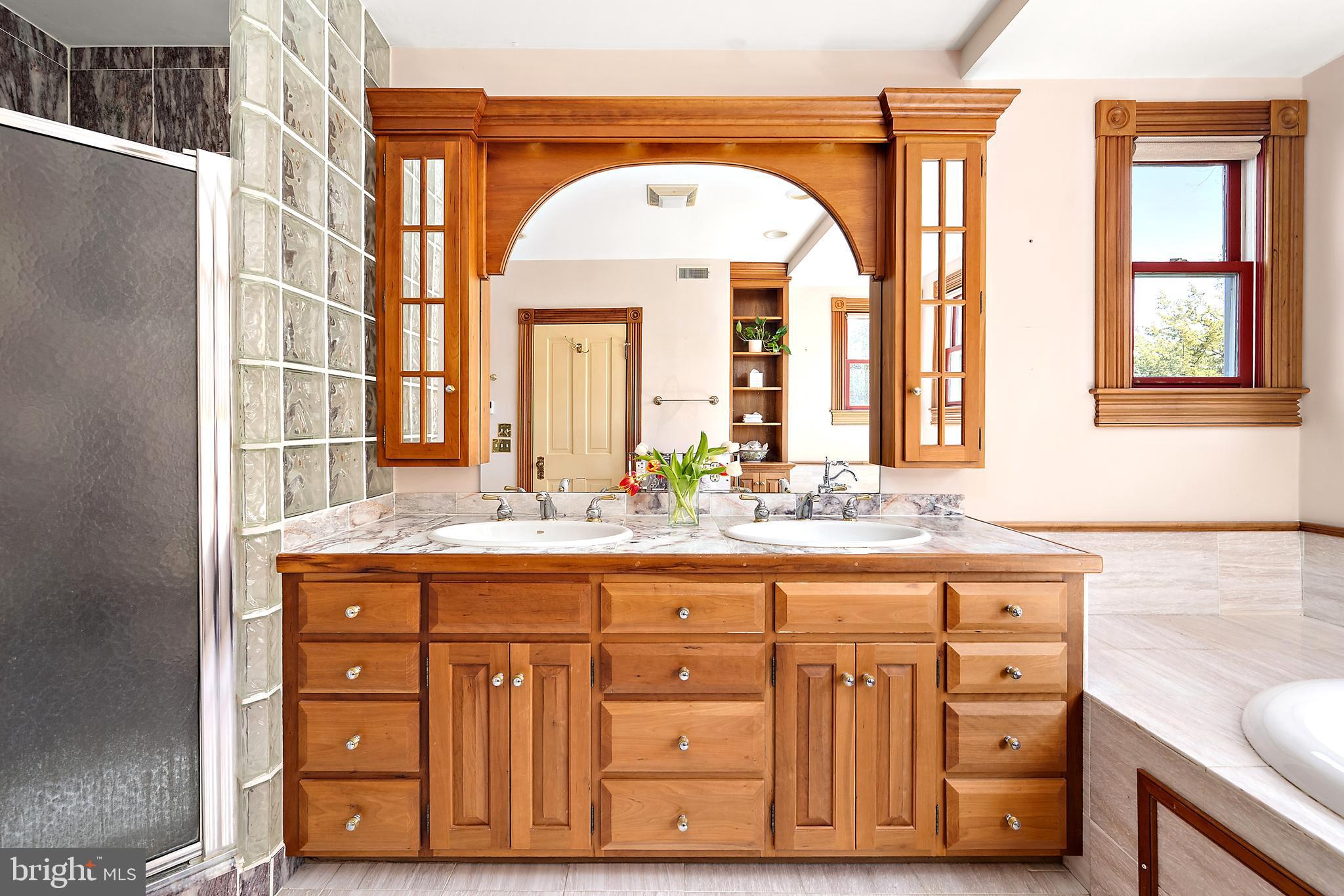 26090 Royal Oak Road Easton, MD 21601 - Photo 38 of 74 a bathroom with a granite countertop double vanity sink a mirror and a bathtub