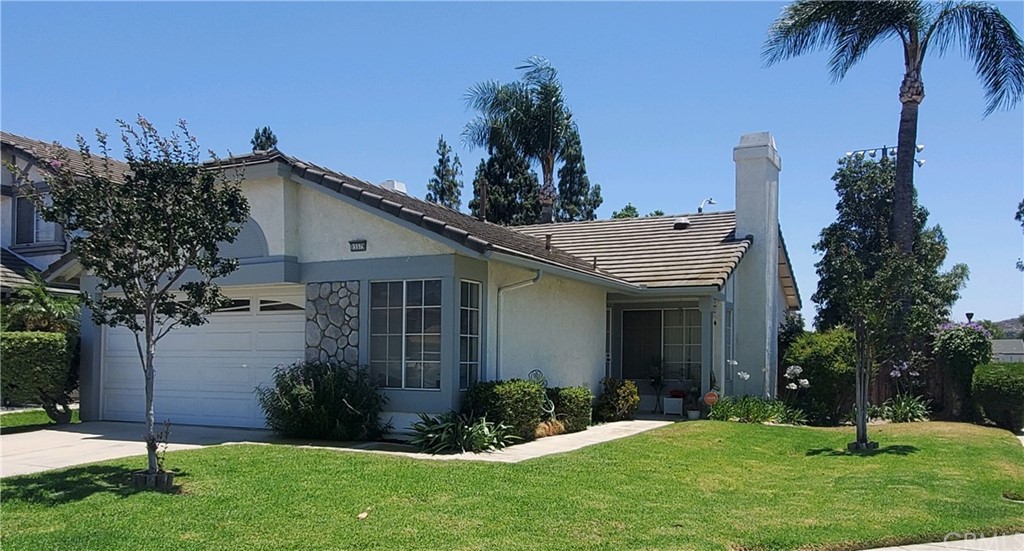 a view of a house with a yard and potted plants