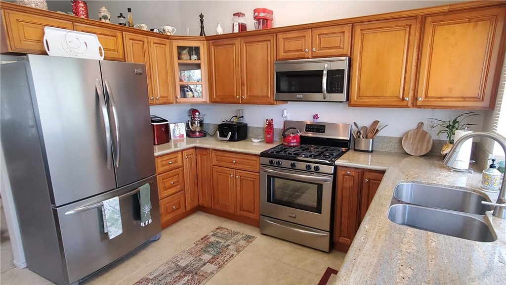 15579 Old Castle Road Fontana, CA 92337 - Photo 2 of 6 a kitchen with stainless steel appliances granite countertop a refrigerator stove microwave and sink