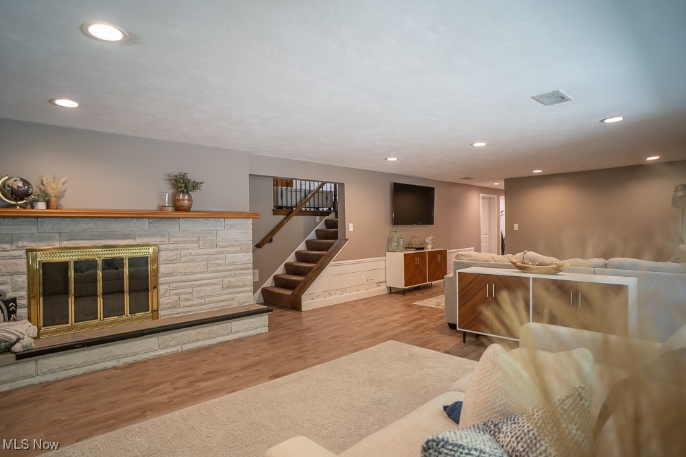 8283 Montello Road Independence, OH 44131 - Photo 19 of 41 Living room featuring light hardwood / wood-style floors and a stone fireplace