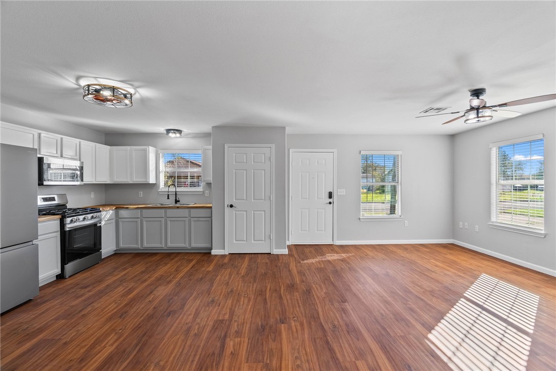 804 Ave B Street Sinton, TX 78387 - Photo 2 of 40 a large kitchen with a wooden floor and stainless steel appliances