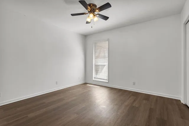 a view of a room with wooden floor and a ceiling fan