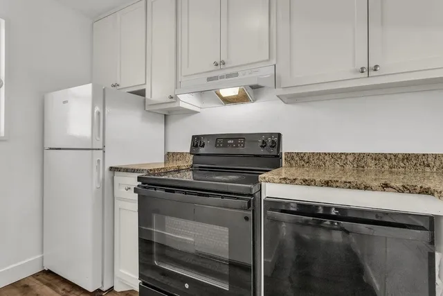 a kitchen with granite countertop cabinets stainless steel appliances and a counter space