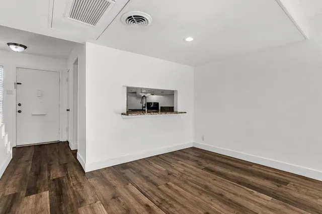 a view of a room with wooden floor and a ceiling fan