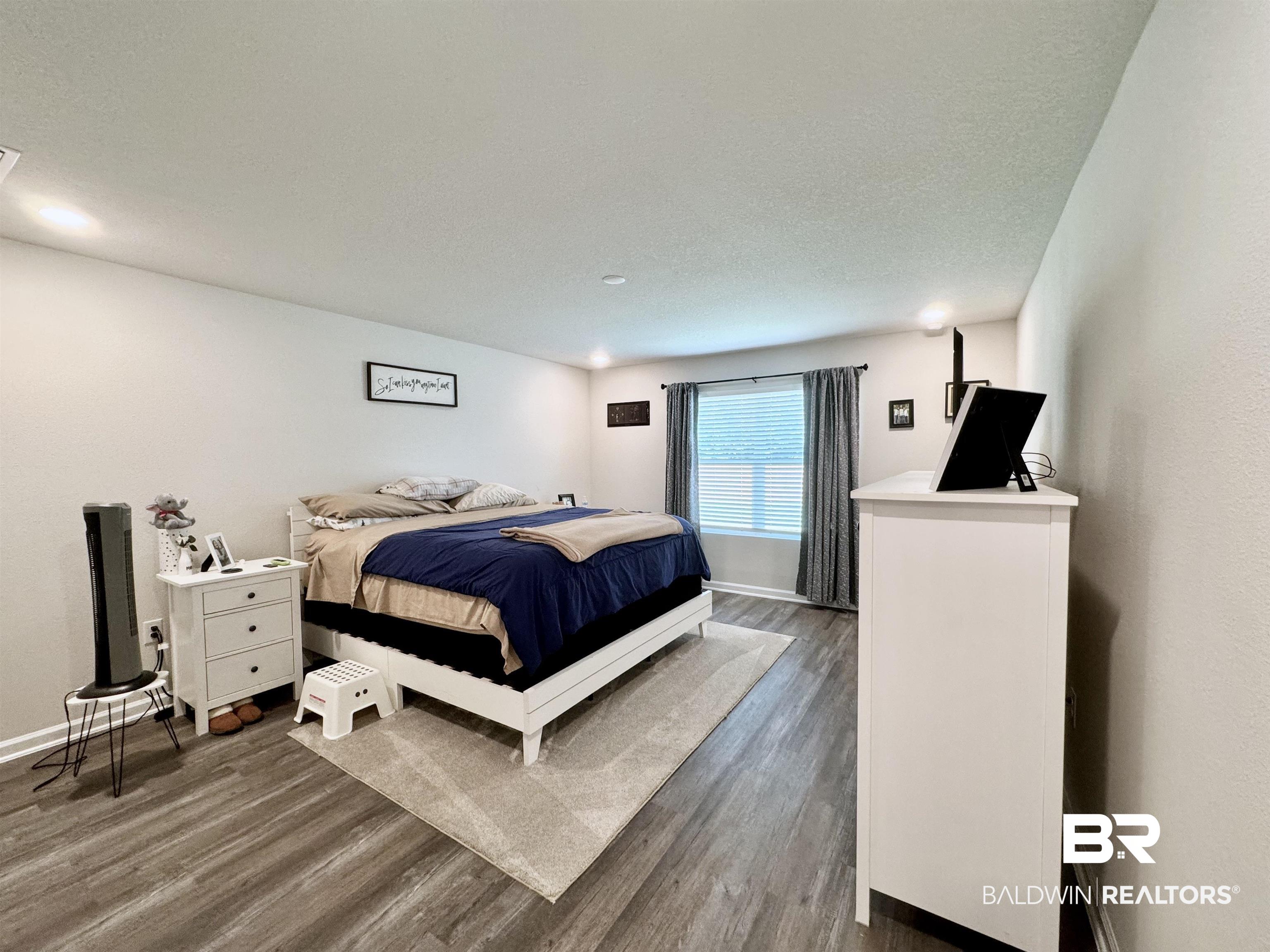 24216 Ringneck Loop Elberta, AL 36530 - Photo 14 of 23 Bedroom featuring wood finished floors and a textured ceiling