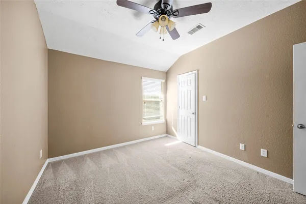 an empty room with closet and a chandelier fan