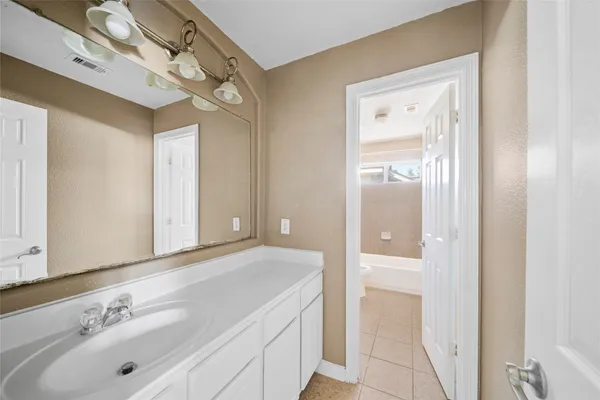 a bathroom with a sink a window and a shower