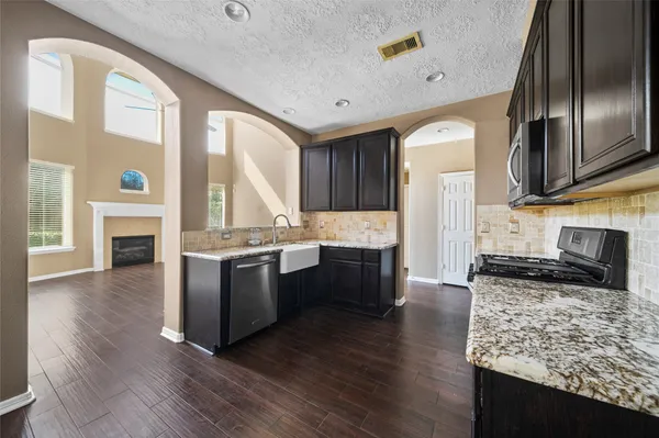 a large kitchen with stainless steel appliances granite countertop a stove a sink and a refrigerator