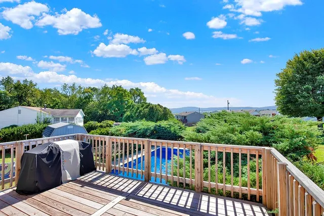 a view of a balcony with wooden floor and outdoor seating