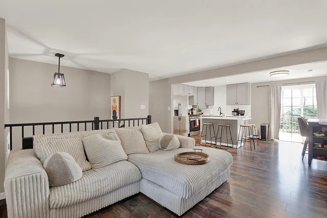 a living room with furniture and view of kitchen