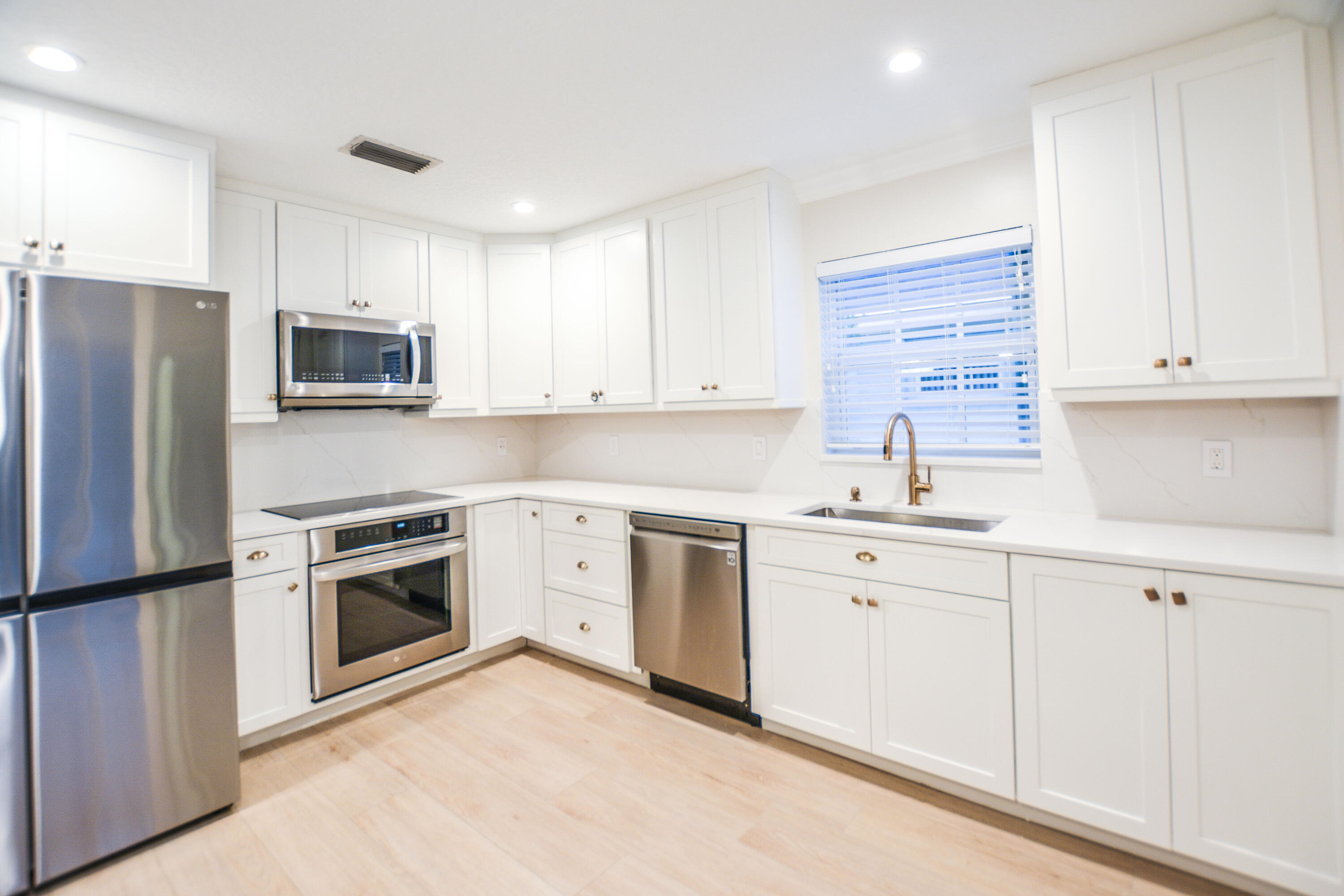 a kitchen with cabinets stainless steel appliances and a window