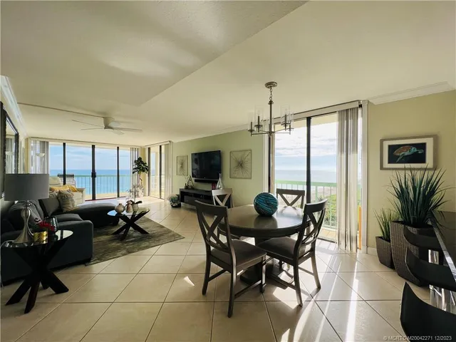 a living room with furniture a flat screen tv and a floor to ceiling window