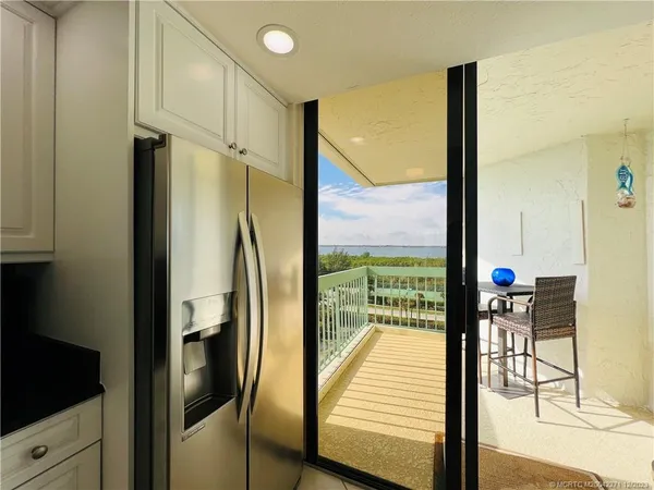 a living room with furniture a large window and a dining table