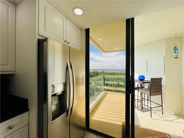 a living room with furniture a large window and a dining table