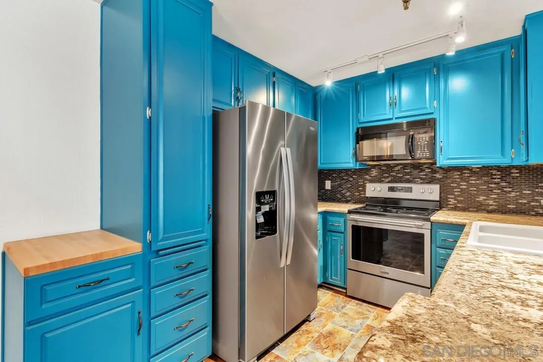 5745 Friars Road, Unit 104 San Diego, CA 92110 - Photo 12 of 38 a kitchen with granite countertop stainless steel appliances and wooden cabinets