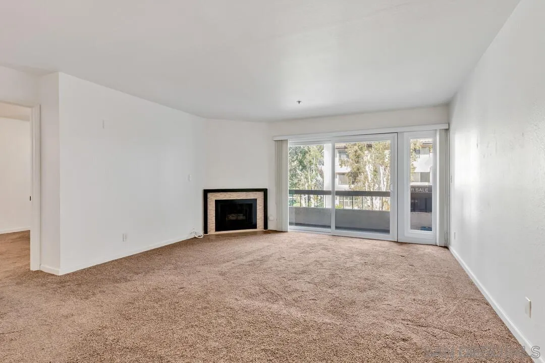 5745 Friars Road, Unit 104 San Diego, CA 92110 - Photo 14 of 37 a view of an empty room with a fireplace and a window